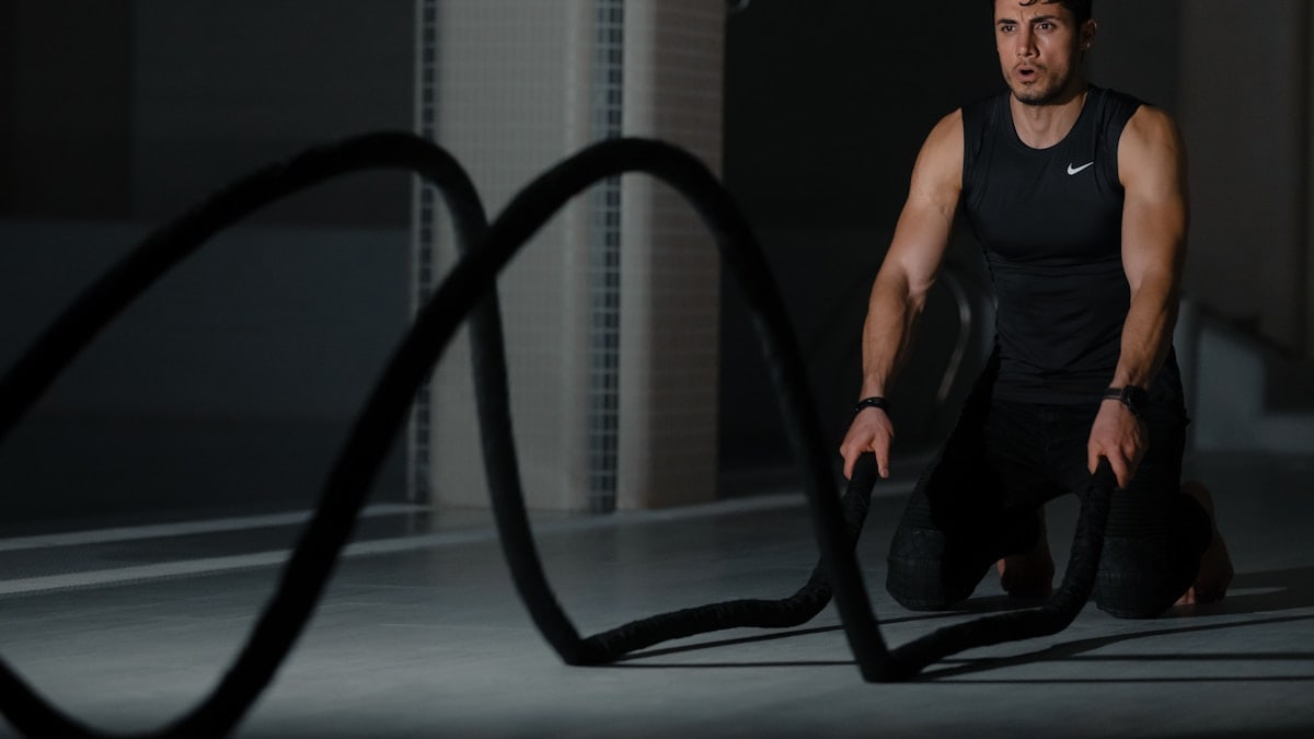 woman in black tank top and black pants sitting on black exercise equipment
